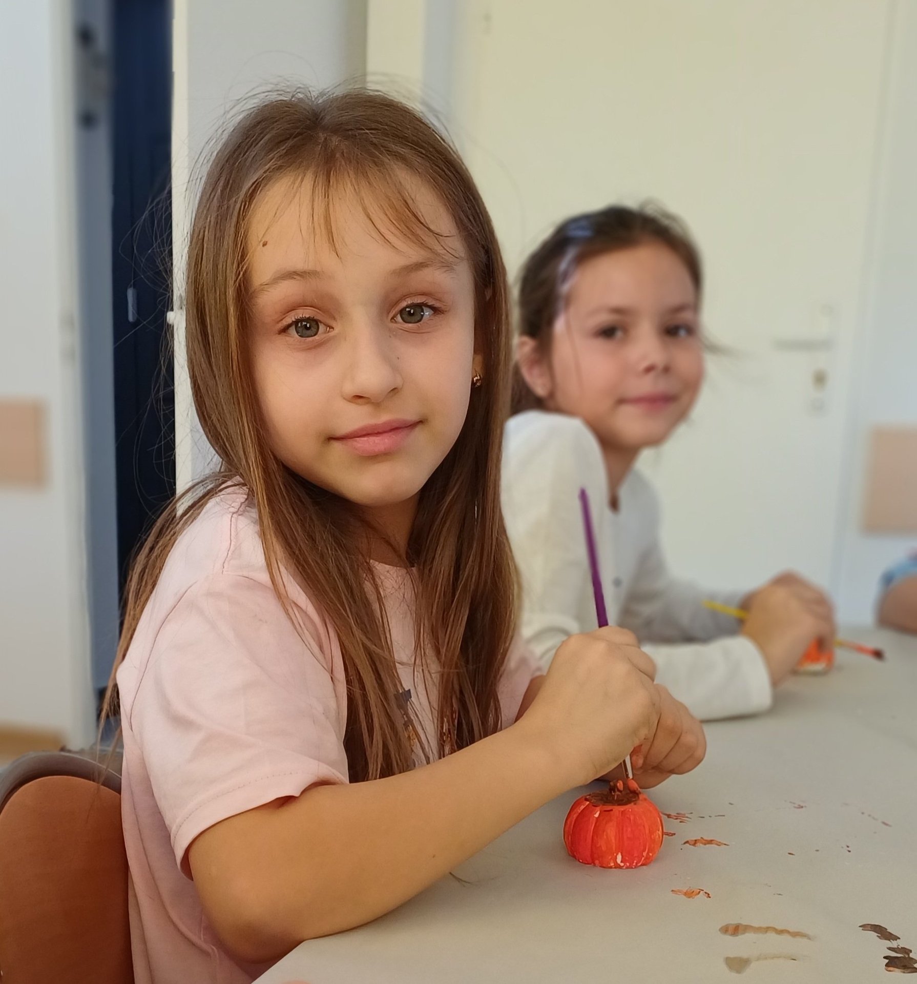 Uśmiechnięta dziewczynka maluje dynie Uśmiechnięta dziewczynka maluje dynie